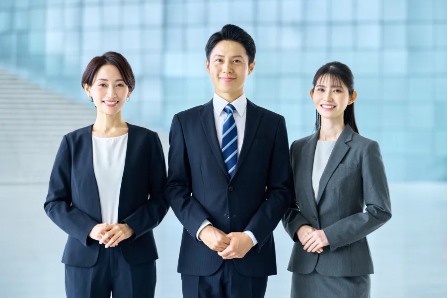 手を組んで正面を向く男女のビジネスマン